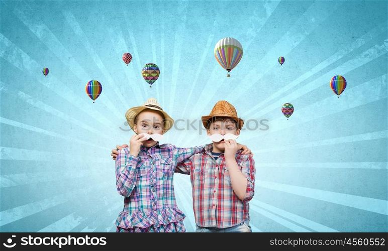 Cute girl and boy wearing shirt hat and mustache. Kids having fun