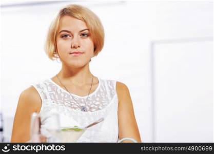 Cute girl at cafe. Portrait of young pretty woman sitting at cafe