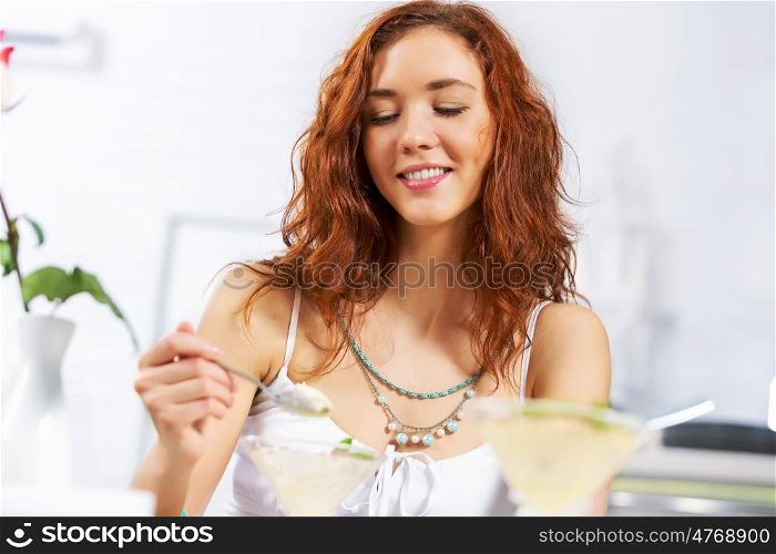 Cute girl at cafe. Portrait of young pretty woman sitting at cafe and eating dessert