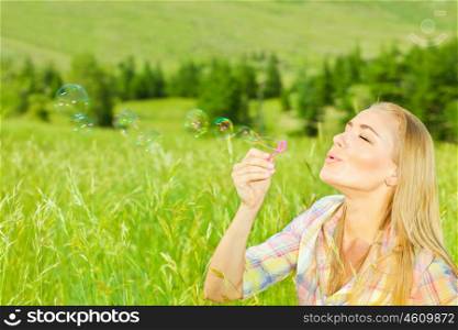 Cute girl blowing bubbles outdoors, beautiful woman spending summer holiday in park, happy female enjoying spring vacation, young lady playing on wheat field, pretty teenager relaxed outside