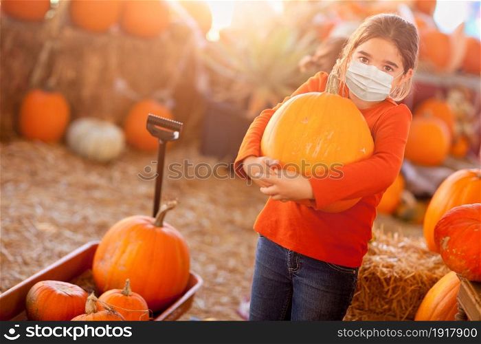 Cute Girl Choosing A Pumpkin At Pumpkin Patch Wearing Medical Face Mask.