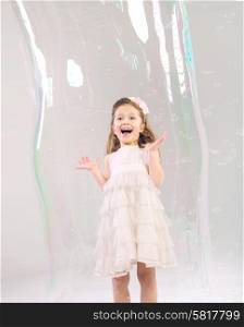 Cute girl in the large soap bubble
