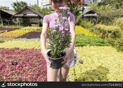 Cute girl is holding flower plant pot