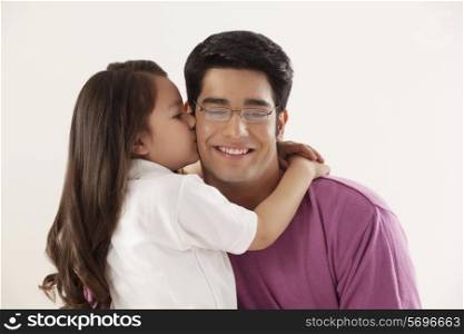 Cute girl kissing her father on white background