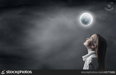Cute girl of school age exploring space system. Profile of girl looking at moon