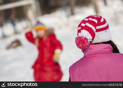 Cute girl of school age having fun in winter park. Winter activity