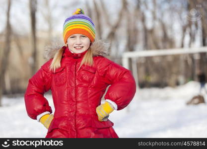 Cute girl of school age having fun in winter park. Winter activity