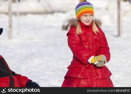 Cute girl of school age having fun in winter park. Winter activity