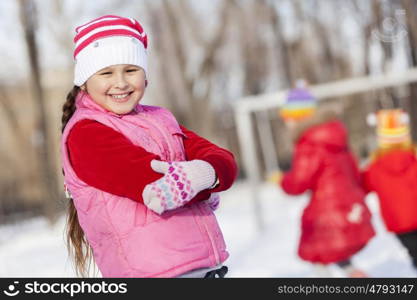 Cute girl of school age having fun in winter park. Winter activity