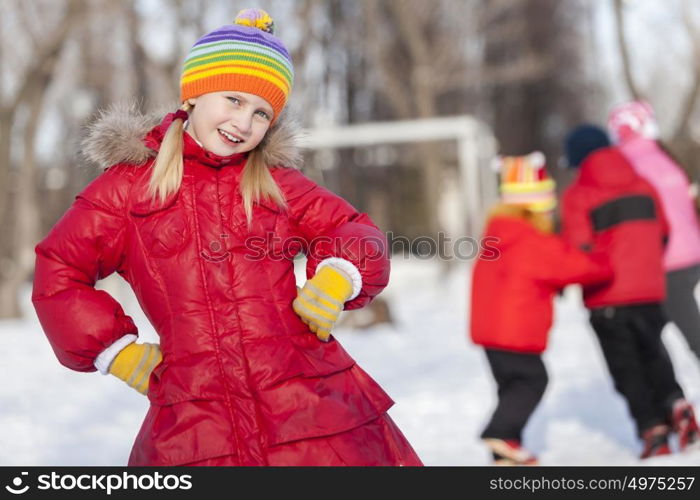 Cute girl of school age having fun in winter park. Winter activity