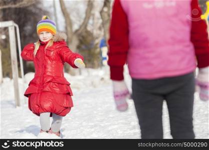Cute girl of school age having fun in winter park. Winter activity