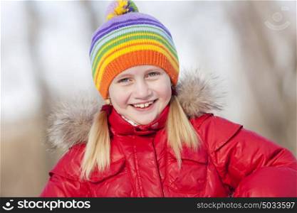 Cute girl of school age having fun in winter park. Winter activity