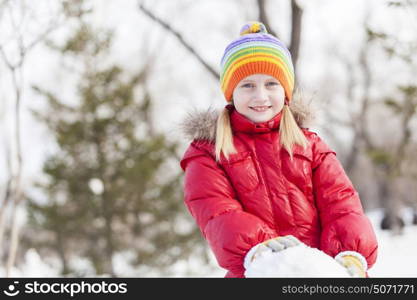 Cute girl of school age having fun in winter park. Winter activity