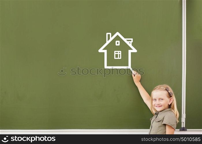 Cute girl of school age writing with chalk on blackboard. Lesson at school