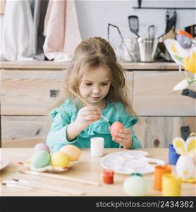 cute girl painting eggs easter