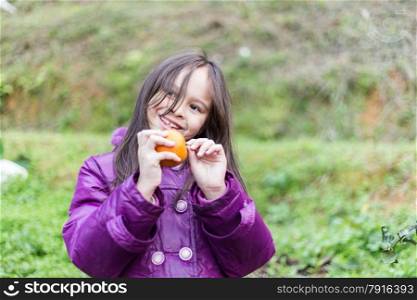 Cute girl peeling an orange at orange farm