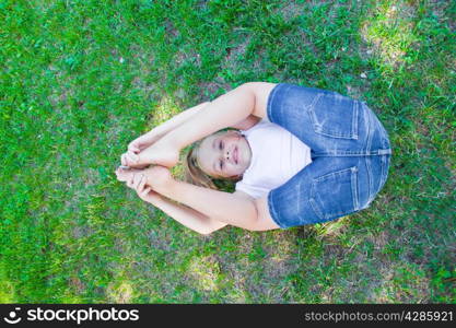 Cute girl playing legs upwards in summer