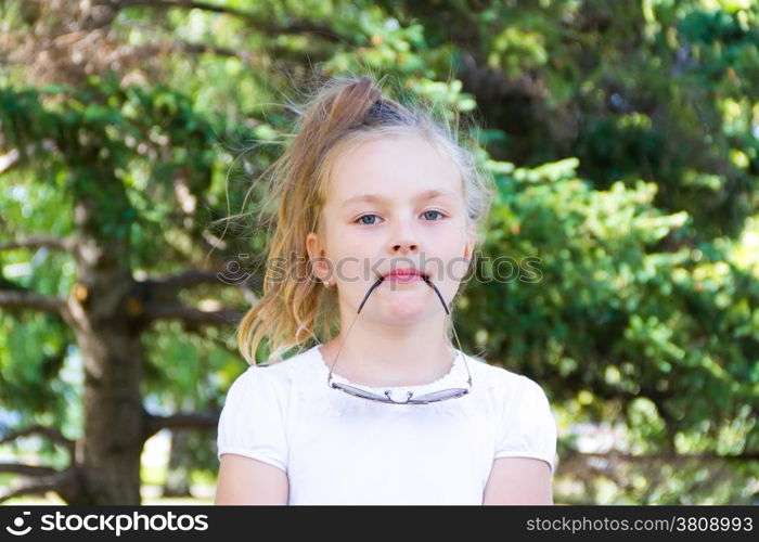 Cute girl playing with sunglasses in summer