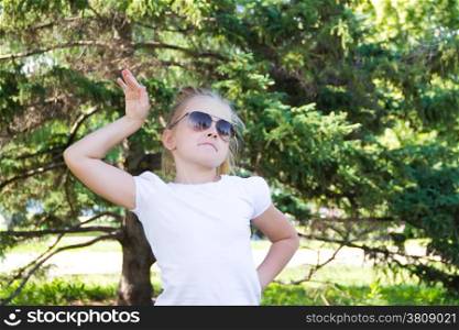 Cute girl playing with sunglasses in summer