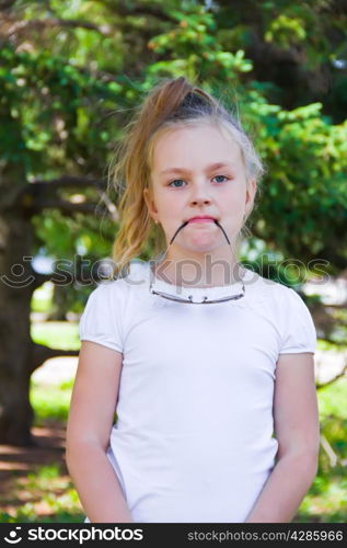 Cute girl playing with sunglasses in summer