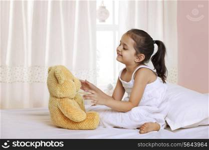 Cute girl playing with teddy bear