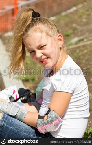 Cute girl put on roller skates in summer