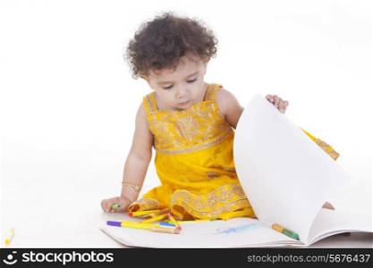 Cute girl turning page against white background