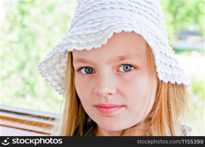 Cute girl with big blue eyes in white hat