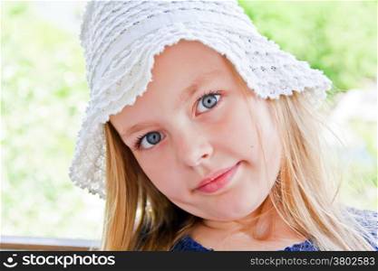 Cute girl with big blue eyes in white hat