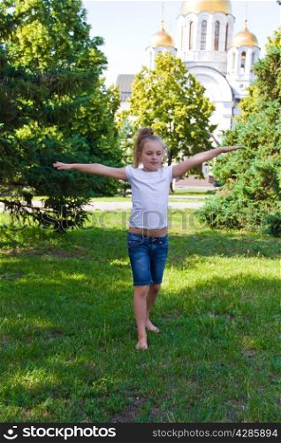 Cute girl with blond hair jumping on one leg