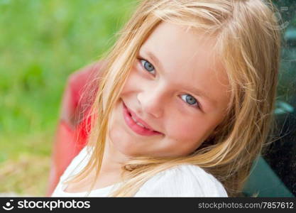 Cute girl with blond long hair and blue eyes