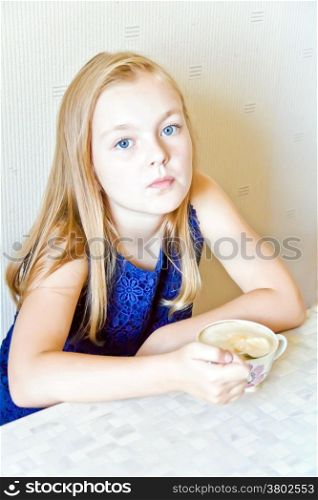 Cute girl with blond long hair drinking beverage