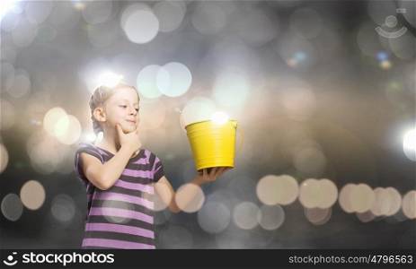 Cute girl with bucket against bokeh background