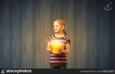 Cute girl with bucket trying to catch the sun
