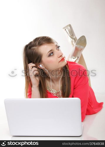 cute girl with headphones listening to music on the laptop on white background