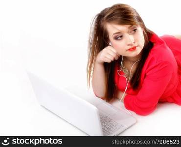 cute girl with headphones listening to music on the laptop on white background