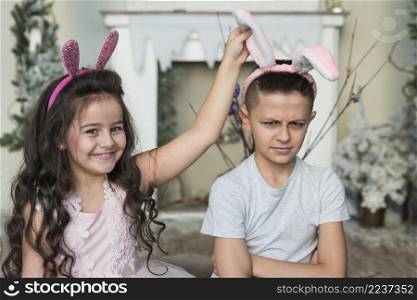 cute girl with offended boy bunny ears