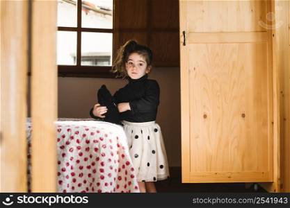cute girl with soft toy standing bedroom
