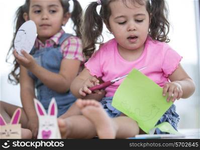 Cute girls with craft papers at home