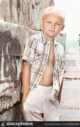 Cute, handsome boy posing on a sunny, tropical beach