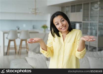 Cute happy puzzled woman, dont know concept. Portrait of young european woman showing positive emotions. Advertising banner mockup. Confused girl in living room at home. Modern interior of apartment.. Cute happy puzzled woman, dont know concept. Confused girl in living room at home.