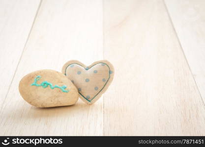 Cute heart handmade crafts from blue polka dot cotton cloth with glitter love word on stone place on wood background, love and valentine&rsquo;s day symbol