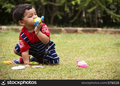 Cute Indian toddler playing with his toys inside a garden, Pune, Maharashtra. Cute Indian toddler playing with his toys inside a garden, Pune, Maharashtra.