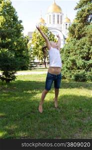 Cute jumping girl with blond hair in summer