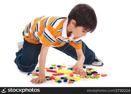Cute kid inprocess of joining the blocks over white background
