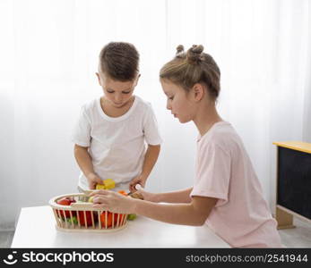 cute kids cutting vegetables