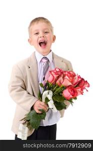 Cute laughing little well-dressed boy standing with big bouquet of red roses