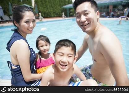 Cute little boy and his family playing in the pool
