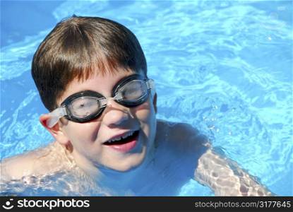 Cute little boy having fun in a swimming pool