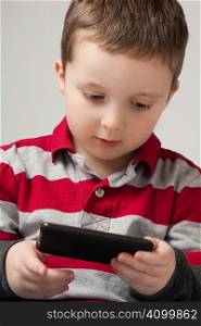 Cute little boy holding a portable video game